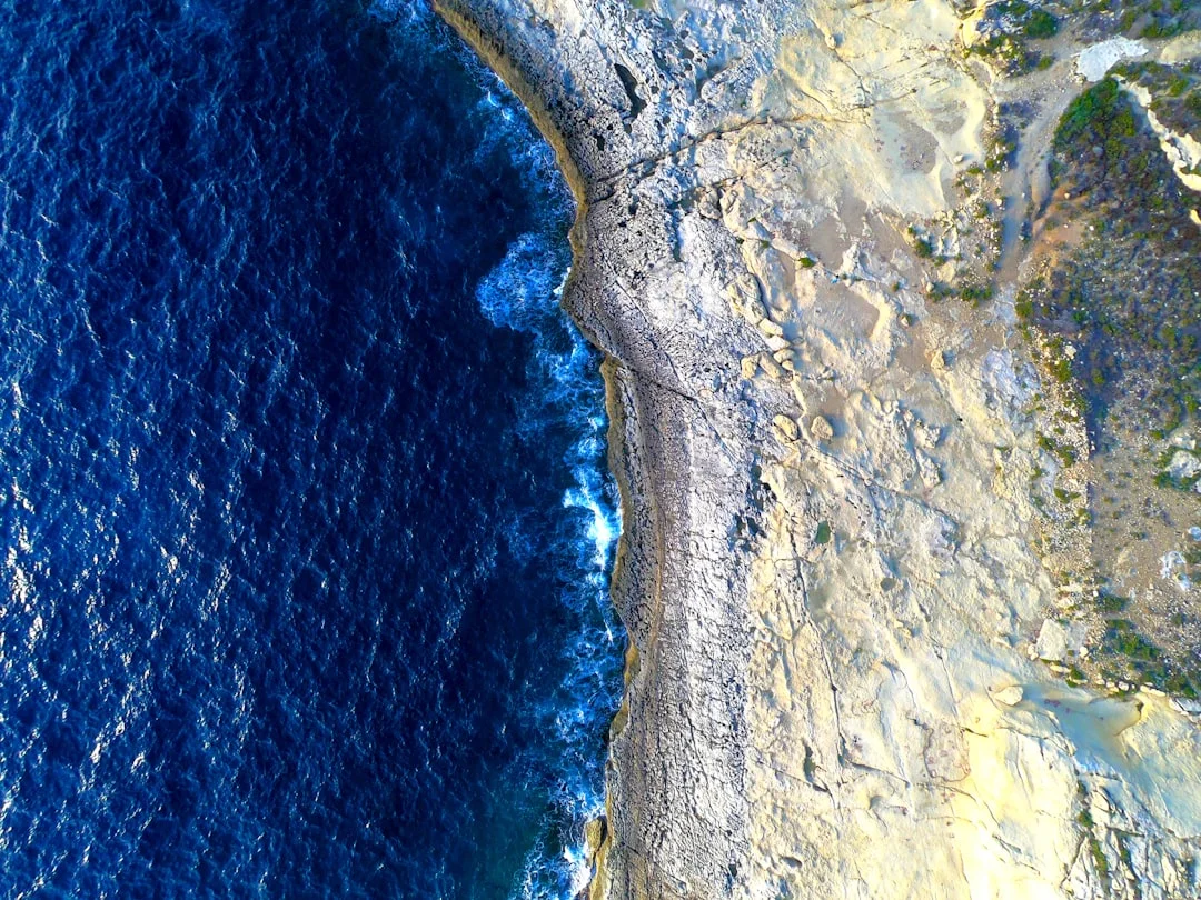 A wide aerial photograph showing multiple resort bays along the Egyptian Red Sea coastline, with clear turquoise water and desert hills beyond.