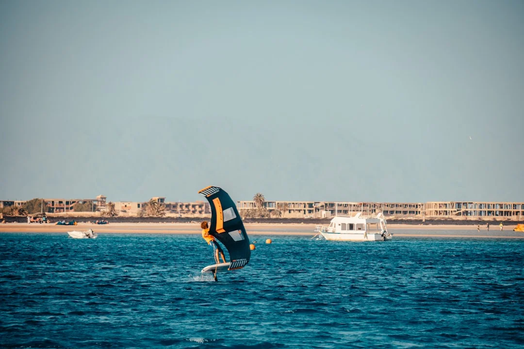 Windsurfer gleiten über den Windkorridor von Safaga in der Nähe der Soma-Bucht bei sanftem Wellengang und goldenem Ufer.