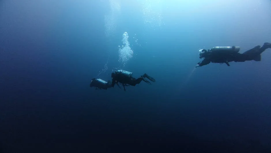 Freitaucher, der an einer Trainingsleine im kristallklaren Wasser des Roten Meeres abtaucht, mit einer Sicherheitsboje über sich.