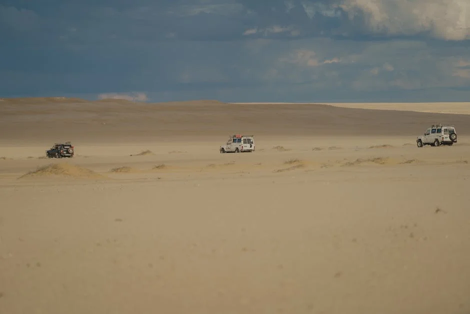 4x4 jeep cresting a dune near Hurghada at sunset with warm orange light