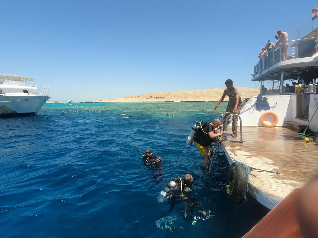 Mutter und Kind schnorcheln ruhig über einem sonnenbeschienenen Hausriff in der Makadi-Bucht, unter dem leuchtende Korallenstöcke zu sehen sind.