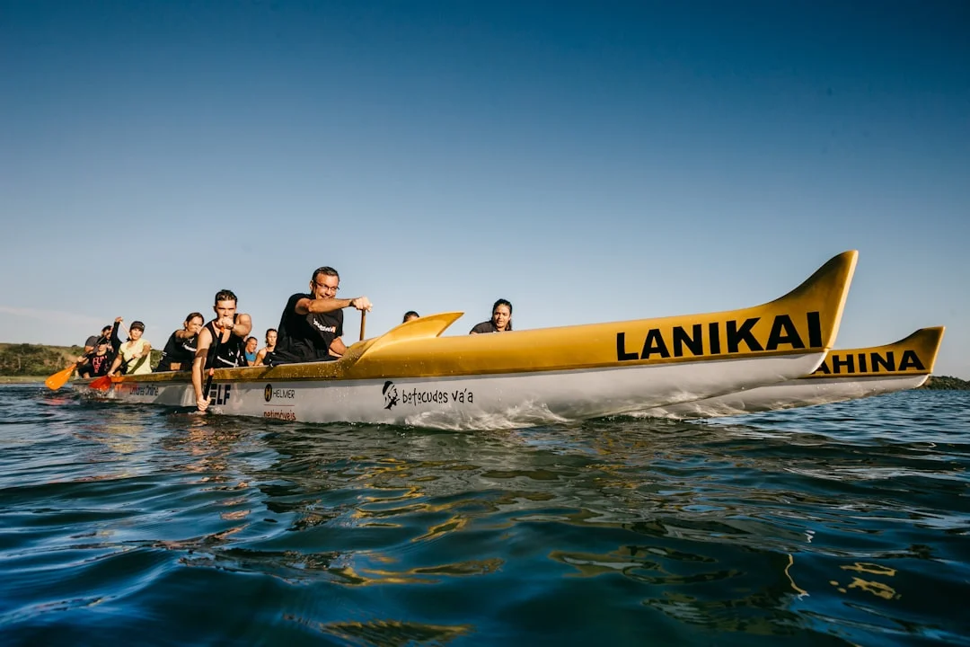 Deux adultes et un enfant font du kayak sur les lagons bleus et calmes d'El Gouna, avec des villas aux teintes pastel à l'horizon.